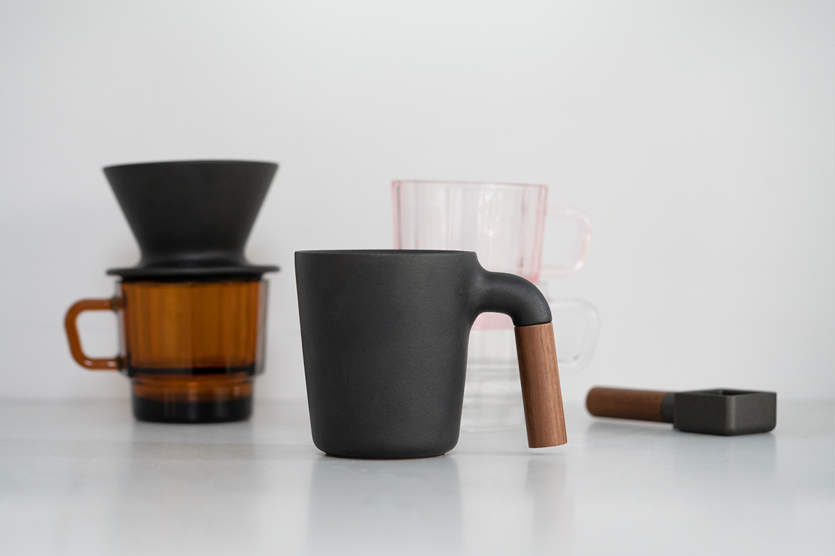 木柄杯 Mugr 是 HMM 「咖啡用」的第一支作品，歷經十一道手工工序，打造溫柔圓潤的手感，鑄鐵杯身與胡桃木手把勾勒出沈靜的桌上風景。